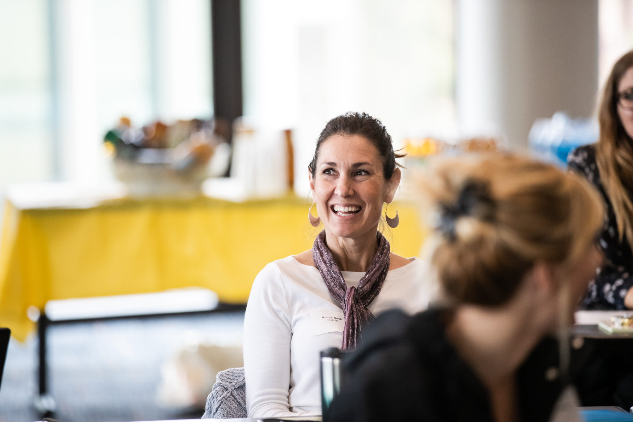 A woman smiles and laughs during a presentation at a CRLP event.