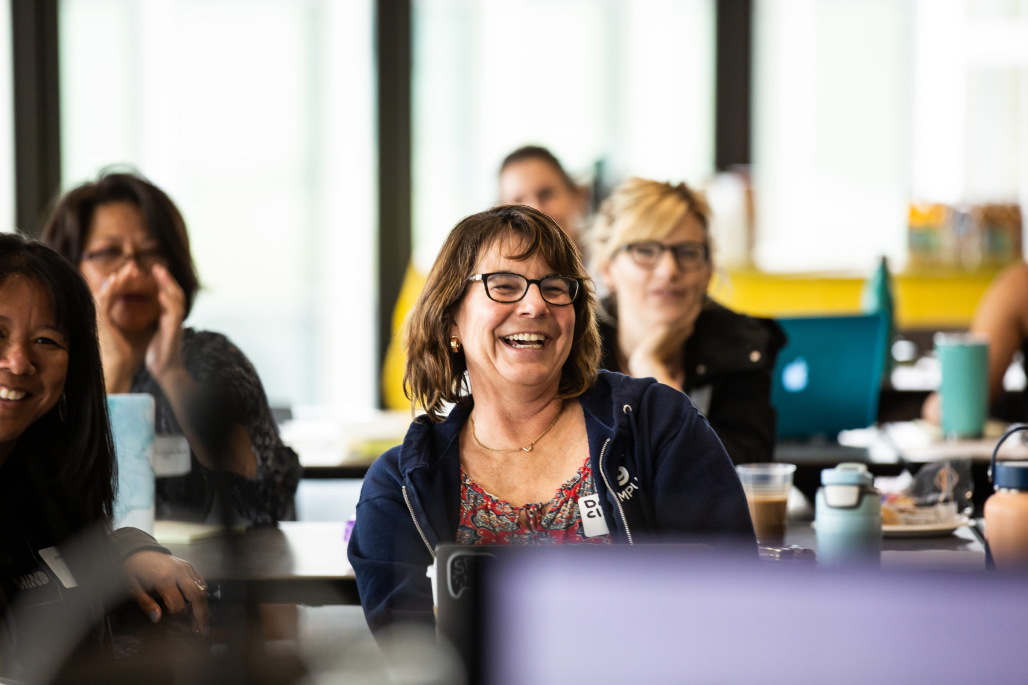 Woman with glasses smiling during a CRLP program