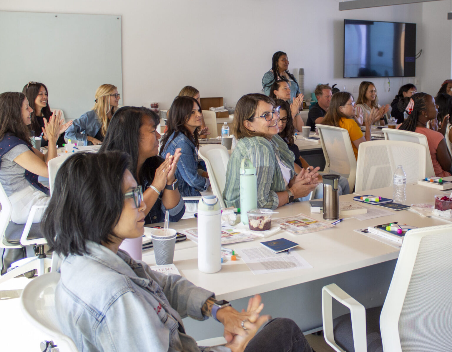 A group of workshop attendees listen attentively during a presentation.