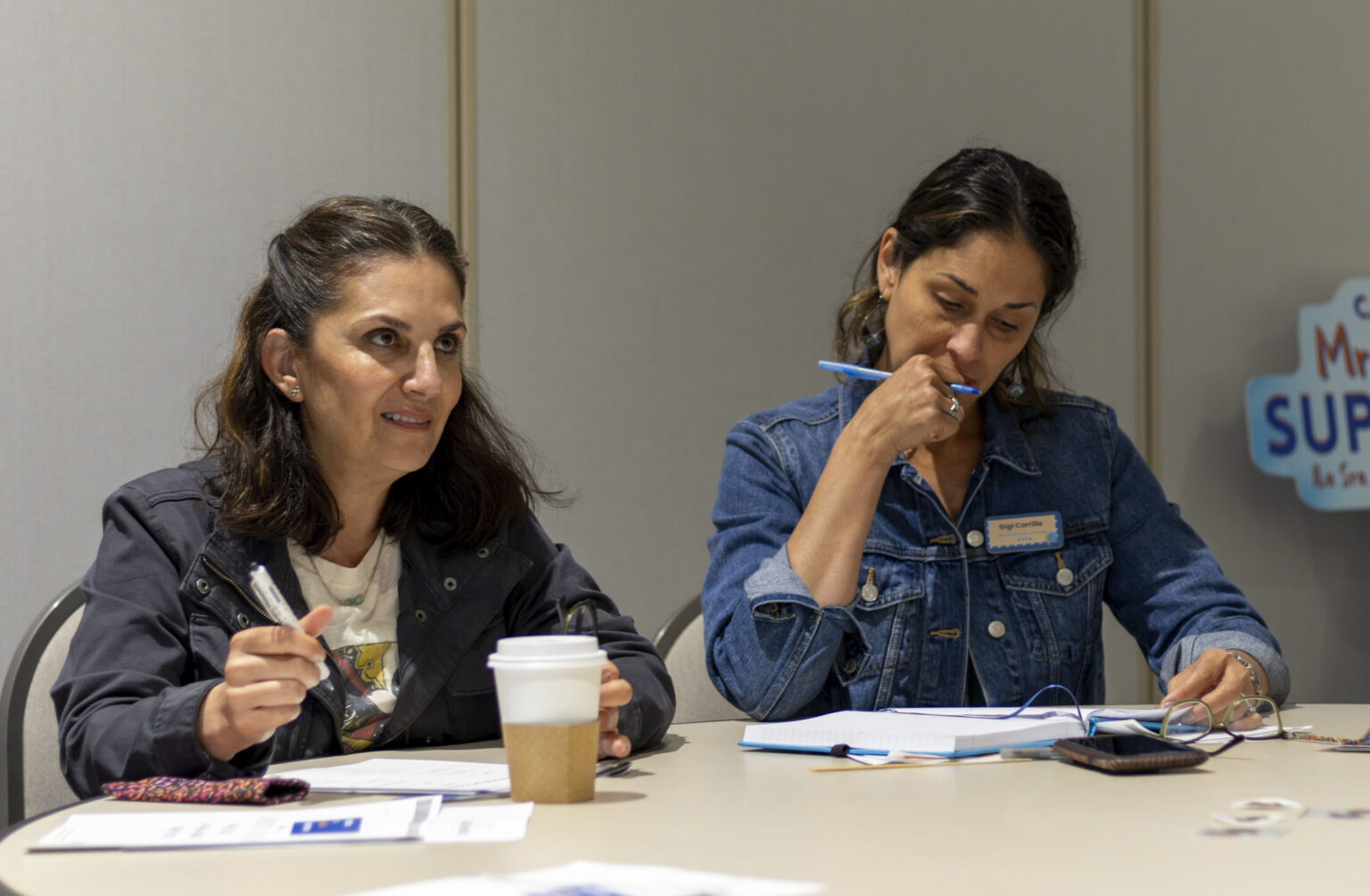 Two women listen and take notes during a CRLP workshop.