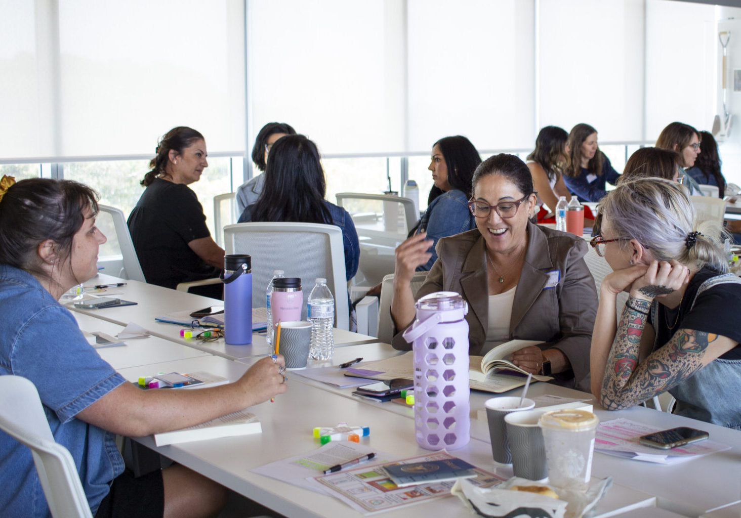 A group of people in a classroom having a discussion about a book.